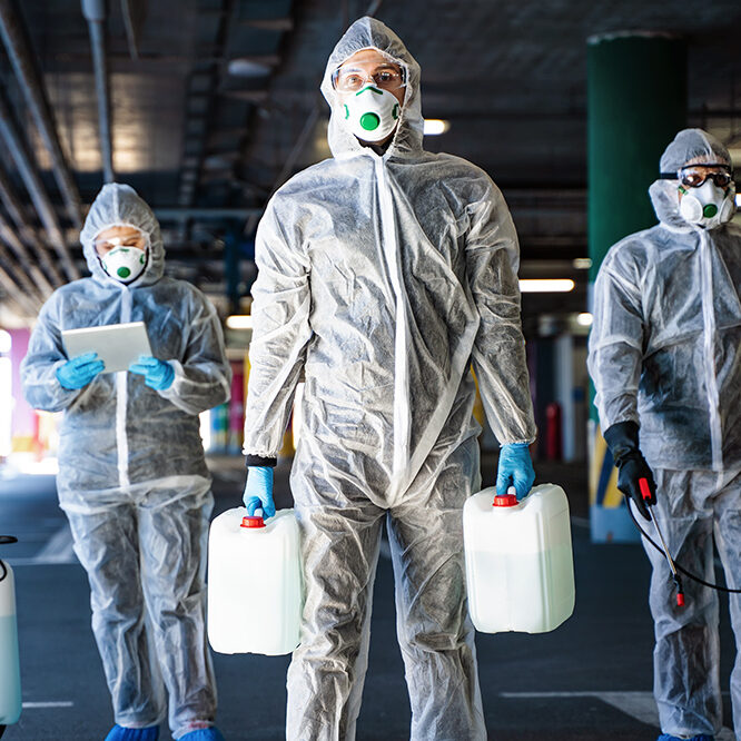 Team of healthcare workers wearing hazmat suits working together to control an outbreak